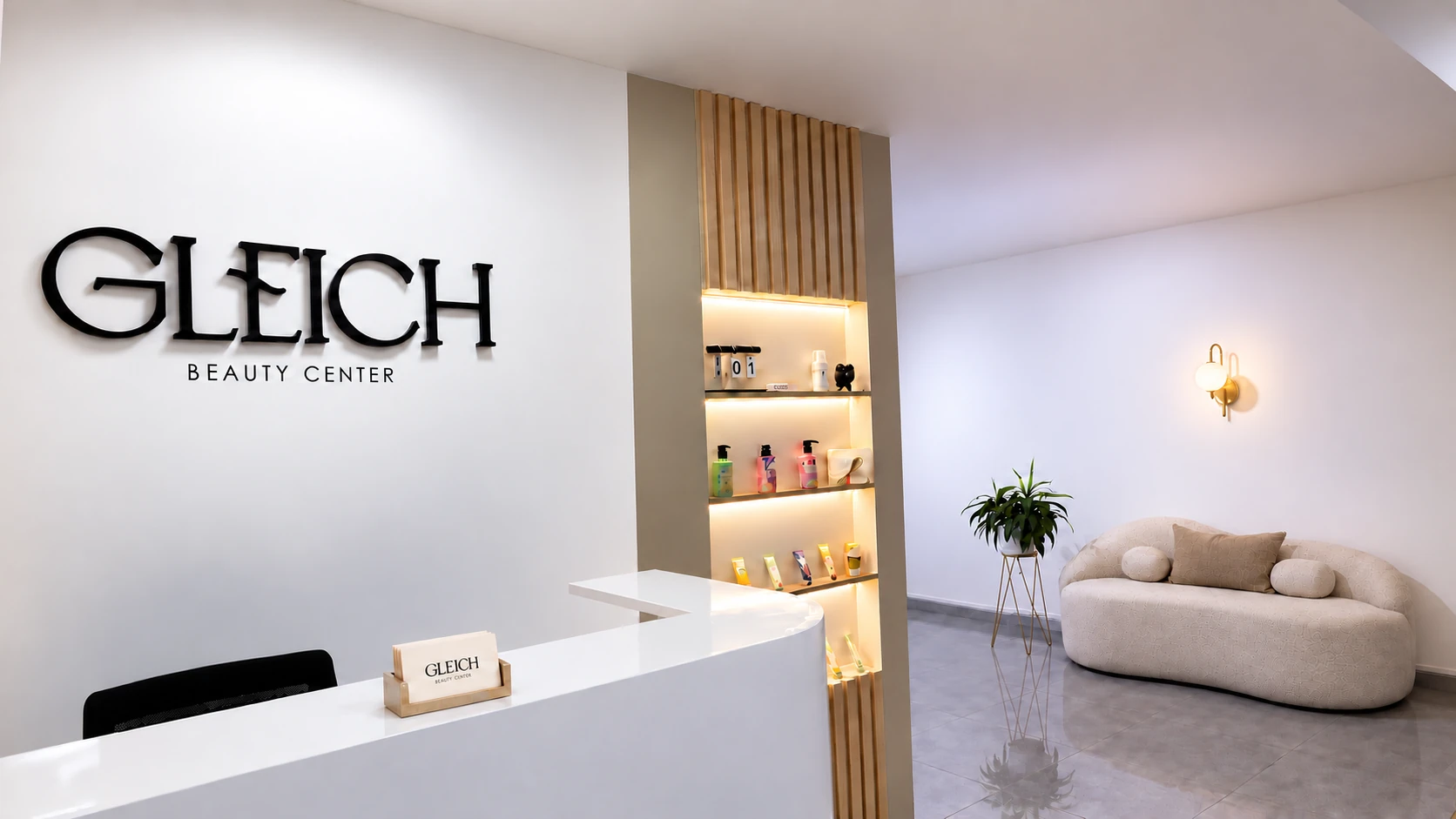 Recepción del centro estético Gleich con pared lisa, logo y luminaria sobre el sillón