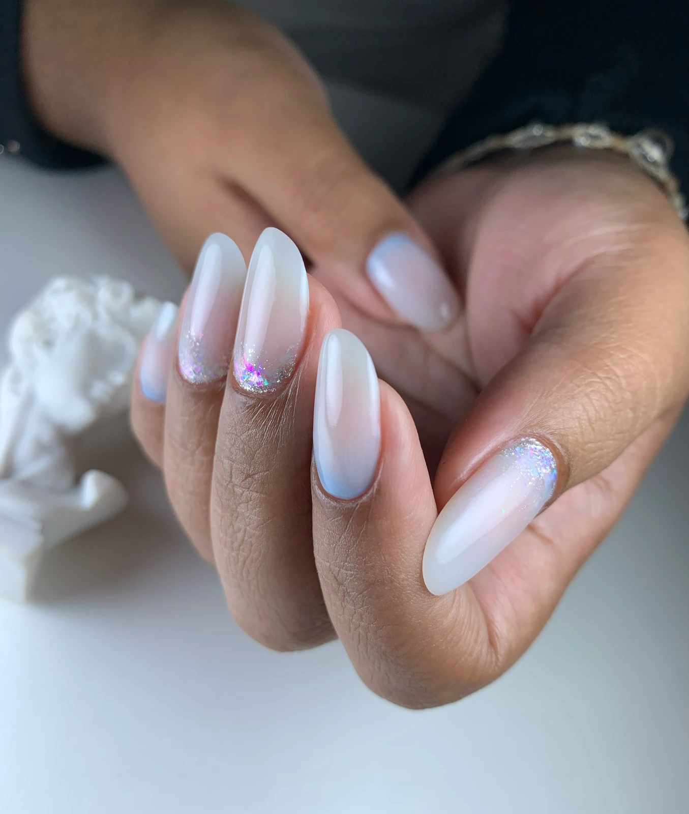 Manicure en tonos claros con acabado degradado y detalles brillantes