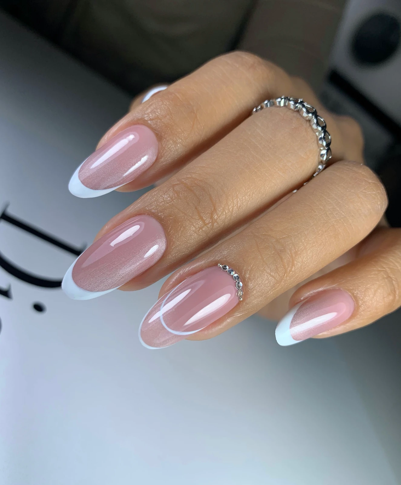 Manicure francesa rosada con líneas decorativas y pequeños cristales